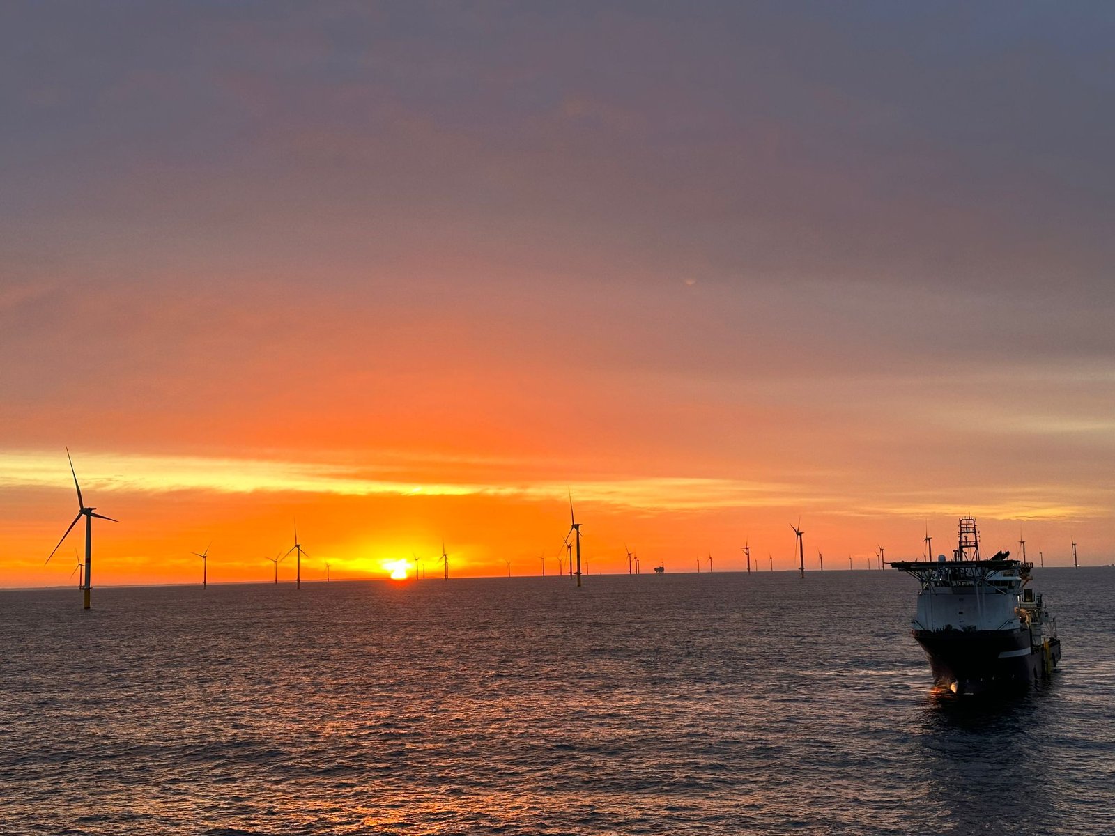 Parc éolien offshore au coucher du soleil — panorama